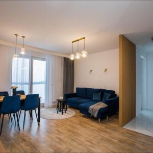 - un salon avec un canapé bleu et une table dans l'établissement Apartament na wynajem 32 m2, à Bochnia