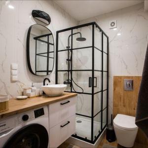 La salle de bains est pourvue d'une douche, d'un lavabo et de toilettes. dans l'établissement Apartament na wynajem 32 m2, à Bochnia