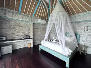 een slaapkamer met een bed en een hangmat. bij Ombak Bay Lembongan in Nusa Lembongan