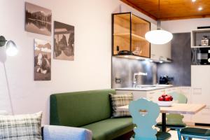 ein Wohnzimmer mit einem grünen Sofa und einem Tisch in der Unterkunft Hapimag Ferienwohnungen St Michael in Sankt Michael im Lungau