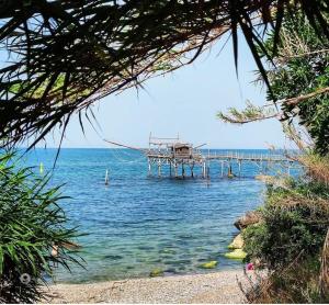 a dock in the water next to a beach at Le Sfumature del Mare in San Vito Chietino