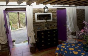 a room with a purple door and a dresser at Piódão Casa do Rosmaninho TER in Coja