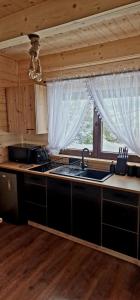 - une cuisine avec un évier et un comptoir avec une fenêtre dans l'établissement Trzy Szczyty-Wysoka, à Grywałd
