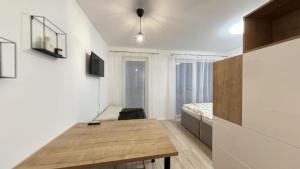 ブラチスラヴァにある1 room Apartment with terrace, Petržalkaの木製テーブルとベッドが備わる客室です。