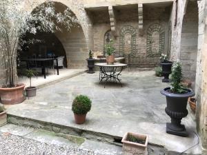 a courtyard with a table and potted plants at Monte Arena Chambre d'hôtes in Montaren-et-Saint-Médiers