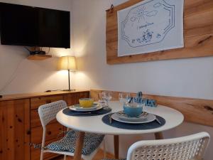 a dining room with a table with chairs and a tv at Przystanek Trześcianka in Trześcianka