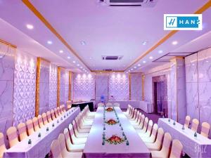HANZ Premium Bamboo Hotel في مدينة هوشي منه: قاعة احتفالات كبيرة مع طاولة وكراسي طويلة