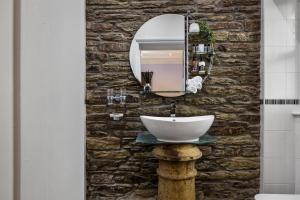 y baño con lavabo y espejo en una pared de piedra. en Caemorgan Mansion, en Cardigan