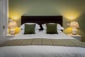 1 dormitorio con 1 cama blanca grande y 2 lámparas en Caemorgan Mansion, en Cardigan