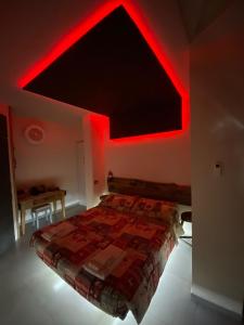 a bedroom with a bed with red lights on it at Lightroom in Fenis