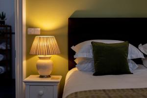um quarto com uma cama e um candeeiro numa mesa de cabeceira em Caemorgan Mansion em Cardigan