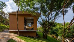 una pequeña casa en medio de árboles en Chalé Aurora da Serra - Lapinha da Serra, en Santana do Riacho
