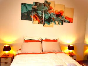 蘇瓦松的住宿－Le Paisible par Picardie Homes，卧室配有一张壁挂着四幅画作的床