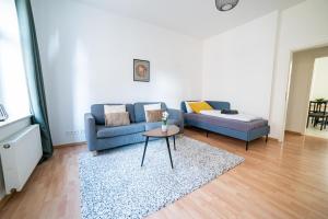 uma sala de estar com um sofá azul e uma mesa em FULL HOUSE Premium Apartments Magdeburg E3 em Magdeburg
