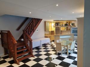 a living room with a staircase and a checkered floor at Bunitrix Guesthouse in Summerstrand