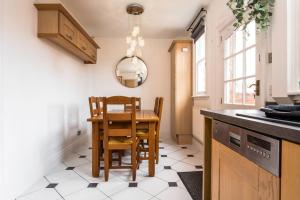 a kitchen with a table and chairs and a mirror at Railway Cottage, Port Sunlight in Bebington