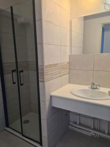 een badkamer met een wastafel en een glazen douche bij Maison 100m de la plage avec parking securise plus fibre optique internet in Valras-Plage