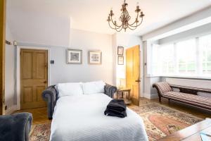 a bedroom with a white bed and a piano at Railway Cottage, Port Sunlight in Bebington