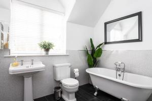 a bathroom with a toilet and a tub and a sink at Railway Cottage, Port Sunlight in Bebington