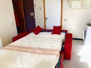 Una cama en una habitación con almohadas rojas. en BELLAVITA, en Pozzallo