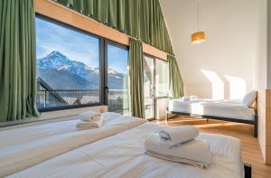 a bedroom with two beds and a large window at Kazbegi View Cottages in Stepantsminda