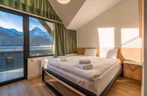 ein Schlafzimmer mit einem Bett und einem großen Fenster in der Unterkunft Kazbegi View Cottages in Kazbegi