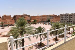 a view of a parking lot with palm trees and buildings at Charming downtown apartment I Fibre Internet Up to 100 Mbps I PALMS Residence in Er Rachidia