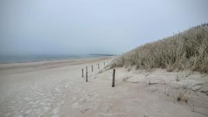 a sandy beach with a fence in the sand at Apartament DANA piękna plaża wydmy las in Ustka