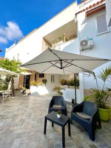 a patio with two chairs and an umbrella at B&B Toci in Volla