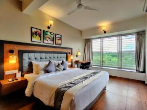 a bedroom with a large bed and a large window at Pushpam Sanskruti Resort Karjat- Pure Veg in Karjat +149 photos