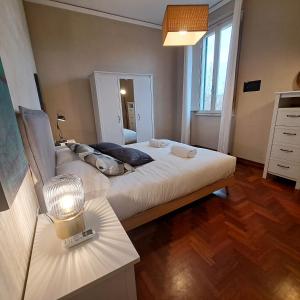 Cette chambre comprend un grand lit blanc et du parquet. dans l'établissement Apartment Corsica 11, à Florence
