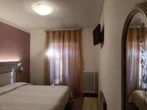 カスティオーネ・デッラ・プレゾラーナにあるAlbergo Ristorante Scanapàの小さなベッドルーム(ベッド2台、窓付)