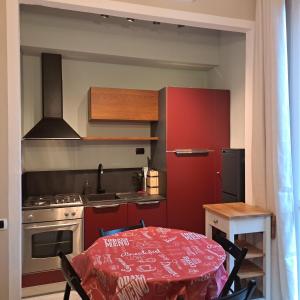 une petite cuisine avec une table et une cuisine rouge dans l'établissement Apartment Corsica 11, à Florence