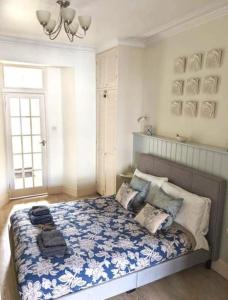 een slaapkamer met een bed met een blauwe en witte deken bij Beautiful Ground floor apartment with Parking, Exeter in Exeter