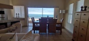 a dining room with a table and a view of the ocean at 25 Sunset View in Langstrand