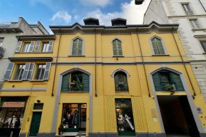 un edificio amarillo con persianas verdes en una calle en Casa Leonardo Da Vinci - 10 minuti dal Duomo en Milán
