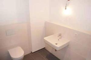 a white bathroom with a toilet and a sink at Fair and City Frankfurt,85square in Frankfurt
