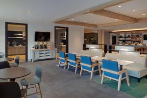 un restaurante con mesas y sillas y una cocina en Hyatt House Columbus OSU Short North en Columbus