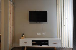 einen Flachbild-TV an der Wand im Wohnzimmer in der Unterkunft Engel apartments -גליל עליון in Tsiv'on