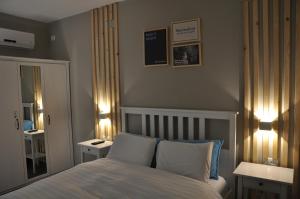 a bedroom with a bed with two tables and two lamps at Engel apartments -גליל עליון in Tsiv'on