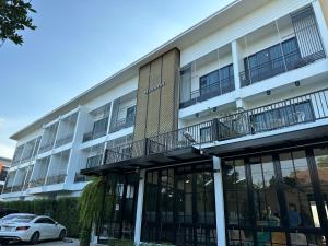 a building with a car parked in front of it at Mosstel in Phitsanulok