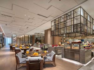 um restaurante com mesas e cadeiras e um buffet em Pullman Huai'an 淮安铂尔曼酒店 em Huai'an