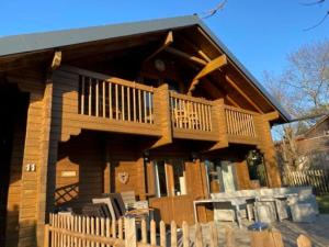 ein großes Holzhaus mit einem Balkon und einem Tisch in der Unterkunft Eifelcottage in Ulmen