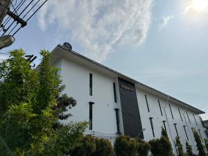 un edificio blanco con un cielo en el fondo en Mosstel, en Phitsanulok