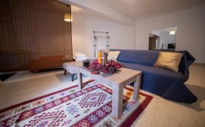 a living room with a blue couch and a table at Trikala center in Tríkala