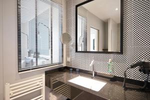 La salle de bains est pourvue d'un lavabo et d'un miroir. dans l'établissement Les 2 Villas, à Trouville-sur-Mer