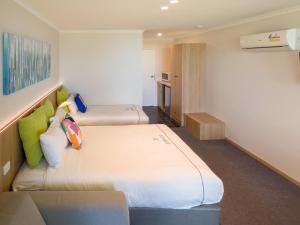 Habitación de hotel con 2 camas y sofá en A1 Motels and Apartments Port Fairy, en Port Fairy