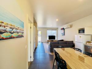 a kitchen and a living room with a couch and a table at A1 Motels and Apartments Port Fairy in Port Fairy