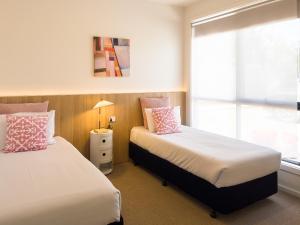 1 dormitorio con 2 camas y ventana en A1 Motels and Apartments Port Fairy en Port Fairy