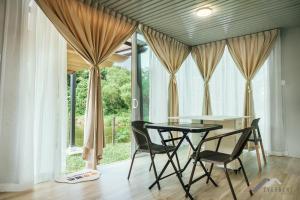 a dining room with a table and chairs in front of a window at Evernent Lakeside Hideout in Miri